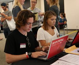 Student sitting at computer with name tag